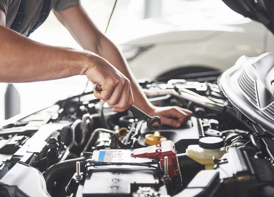 Picture showing muscular car service worker repairing vehicle.